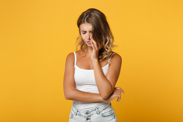 Displeased young woman in light casual clothes posing isolated on yellow orange wall background,...