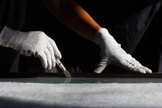 Technicians are using cutting tools  cut glass according to customer size