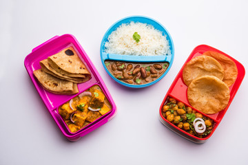 Fototapeta na wymiar Group of North Indian Food in Tiffin , Lunch Box includes Rajma or Razma Chawal, paneer Butter Masala Roti or Paratha and choley puri / Poori / Bhature, selective focus
