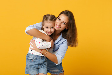 Woman in light clothes have fun with cute child baby girl 4-5 years old. Mommy little kid daughter isolated on yellow background studio portrait. Mother's Day love family parenthood childhood concept.