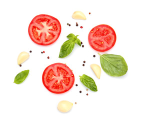 Pieces of fresh tomato and spices on white background