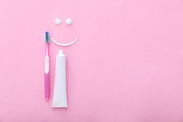 Tooth brush, paste and drawn smile on color background