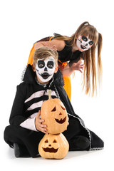 Little children in Halloween costumes and with pumpkins on white background