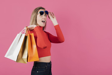 Girl with sunglasses holding shopping bags