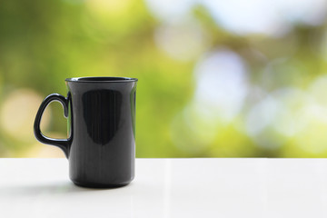 Obraz premium A black coffee mug on a white table On a natural background