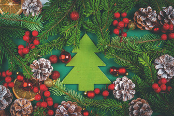 Christmas background with cones and pine branches on green