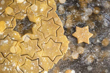 Raw christmas homemade gingerbread dough rolled out on dark table