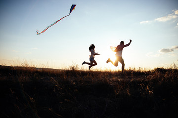 Young couple have fun with kite. they send Genuine emotions  to the world.