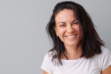 Fototapeta premium Beautiful woman middle age posing over a grey background