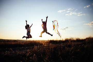 Young couple have fun with kite. they send Genuine emotions  to the world.