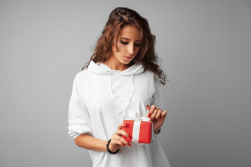 Nice woman holding a red gift box in her hands