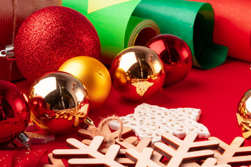 Close up shot of wrapping paper and items for christmas decorating on red background