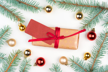 Christmas craft gift surrounded with pine tree branches and mini baubles