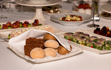 Bread rolls on a gala table in a restaurant under a white napkin