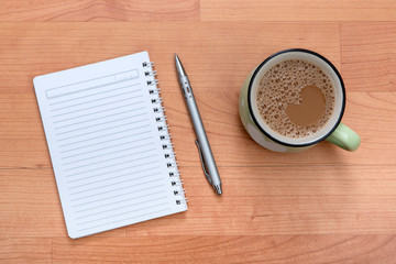 Workplace top view of coffee and note pad 