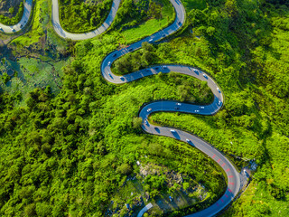 Aerial view of winding road through valley of the mountain. Top view from drone.