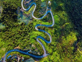 Aerial view of winding road through valley of the mountain. Top view from drone.