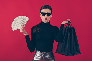 Portrait of her she nice-looking attractive trendy lady holding in hands black bags large budget sum money finance expense pout lips isolated on maroon burgundy marsala red pastel color background