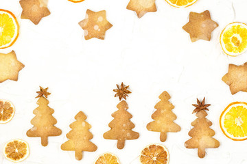 Fototapeta na wymiar Christmas tree cookies with star toppers and dry orange on white background with copyspace.