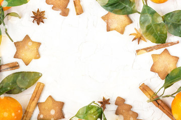 Border of Christmas star cookies with spices and mandarin on white background with copyspace.