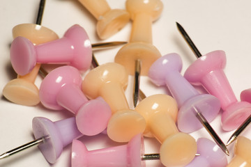 A bunch of multicolor bright pink and yellow pins on paper