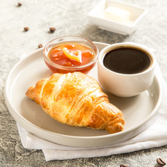 breakfast with croissants. fresh crispy croissants and coffee on a light .background, top view..