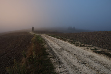 autumn on hill hills of tuscany italy during a foggy day morning