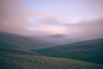 autumn on hill hills of tuscany italy during a foggy day morning