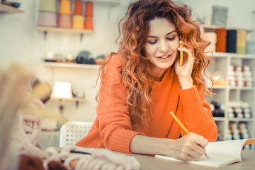 Positive delighted young woman talking per telephone