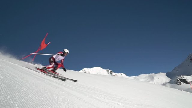 slow motion professional ski racer skiing super g high up in mountains