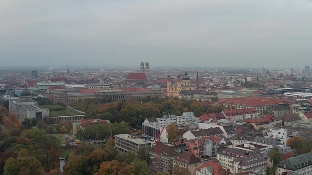Panning shot with a drone over Munichs English Garden in the colorful autumn.
