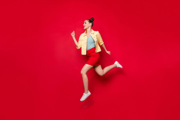 Fototapeta na wymiar Full body photo of pretty jumping lady running fast to shopping wear casual outfit isolated red background