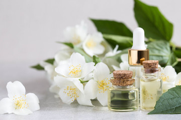 Obraz na płótnie Canvas Essential jasmine oil. Massage oil with jasmine flowers on a wooden background
