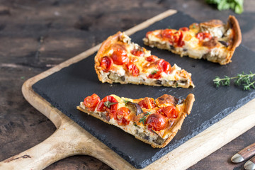 Vegetarian homemade pie, Quiche with cherry tomatoes, eggplant and feta cheese on a dark background