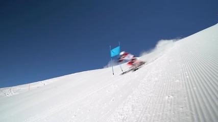 4K sport footage, professional ski racer with start number one skiing super g on sunny winter day with clear blue sky