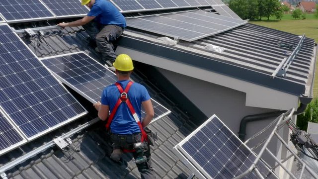 Solar Panels Being Installed On Roof Of House By Installers. Aerial