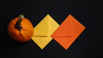 Greeting card, holiday decorations, colorful envelopes and orange pumpkin isolated