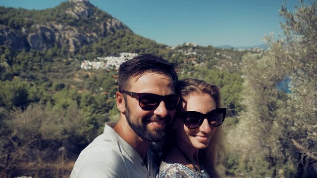Selfie Couple On Beautiful Place.Couple Taking Selfie On Seashore Mediterranean Coast.Lovers Taking Self Photo And Answer To Video Call On Sea Mountains.Pair Takes Pictures On Smartphone On Seashore.