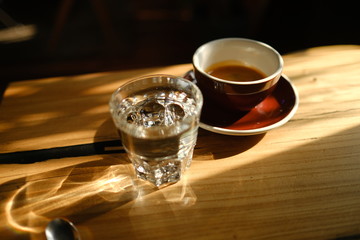 black coffee in a cup and a glass with water