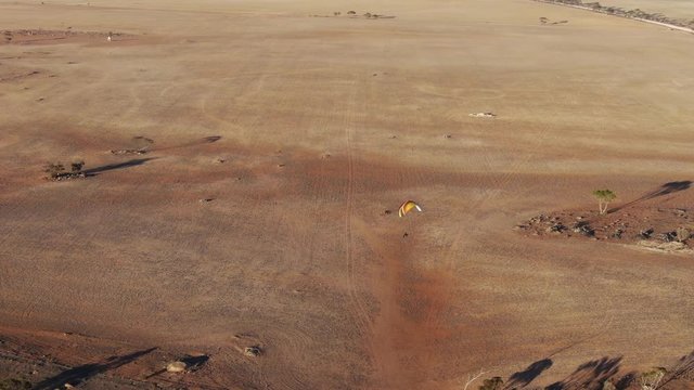 Nice long distance bird eye view of paramotors enjoying flying in early time over the wide land in rural place 