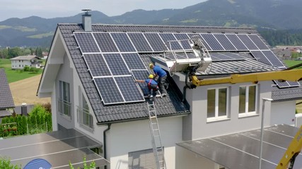 Installers Fitting Solar Panels On Roof With Crane. Slow Aerial Dolly Back