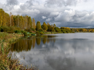 wonderful autumn landscape with gorgeous and colorful trees by the river, beautiful reflections in the water