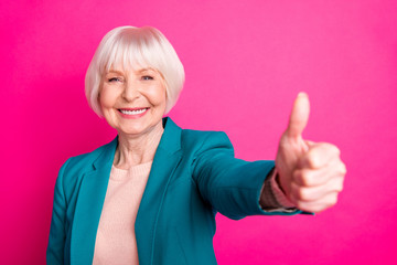 Close-up portrait of her she nice attractive cheerful content gray-haired lady wearing blue green jacket showing giving thumbup isolated over bright vivid shine vibrant pink fuchsia color background