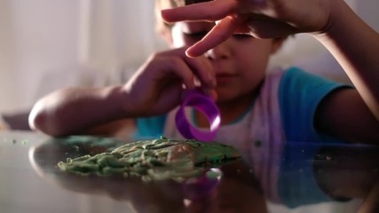 children play with plasticine figures at home while watching television