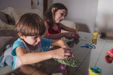 children play with plasticine figures at home while watching television