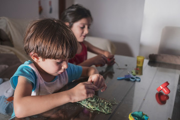 children play with plasticine figures at home while watching television