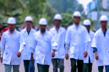 Abstract, blurry, bokeh background, image for the background. People in overalls in production