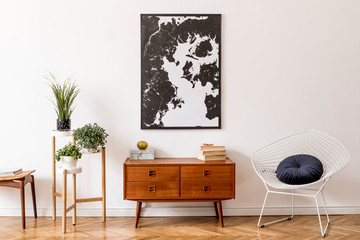 Stylish interior design of living room with wooden retro commode, white armchair, footrest and...