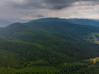 Fototapeta premium Aerial view over mountain road going through forest landscape. Transylvania, Romania