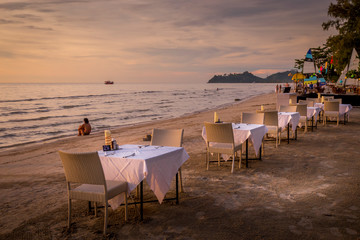 tables on beach in thailand at sunset